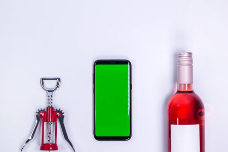 Rose and with corkscrew on white table. Mockup phone. Green screen. Top view with copy space. Space for text. Wine bottle necksの写真素材