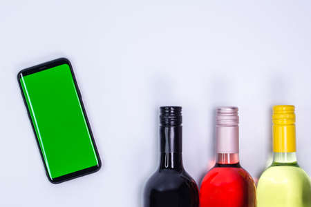 Red, rose and white wine bottles on white table. Top view with copy spaceの写真素材