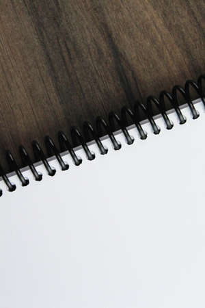 Spiral notepad paper on the wooden background. Vertical and space for textの写真素材