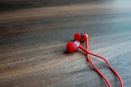 Bright Red earbuds headphones on wooden backgroundの写真素材