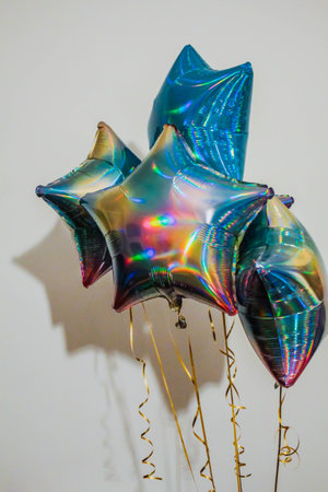 foil blue balloons filled with helium. holographic helium star balloons on white.の写真素材
