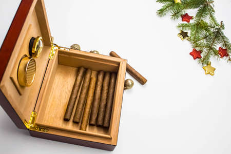 Open cigar humidor on white with holiday decoration. Christmas online shopping. Space for text. Smoking set accessories.の写真素材