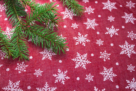 Flat lay frame with fir branches, christmas white snowflakes on red background. Space for text.の写真素材