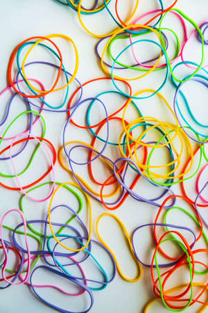 Top view of colorful rubber bands isolated on white. Rainbow elastic rubber bands on white. Space for textの写真素材