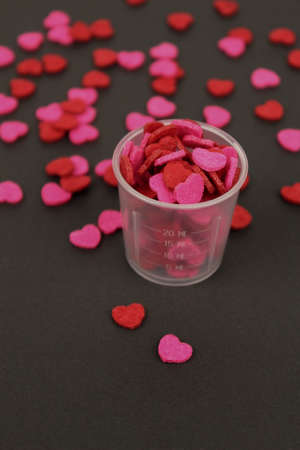 Red Pink Heart Candy in Transparent Cup Dark Background Love Valentine Concept.の写真素材