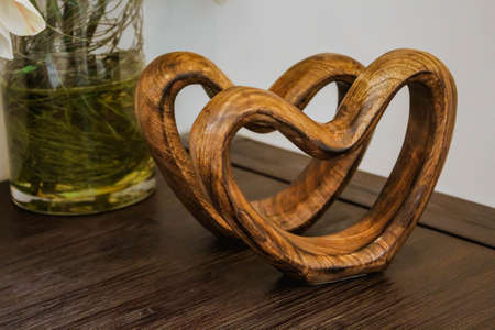 Two handmade wooden carved hearts on a table. Valentine day conceptの写真素材