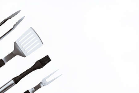 Set with barbecue utensils on white background. Stainless steel spatula, oil brush, tongs, fork for bbq. Copy space.の写真素材