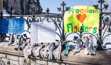 The Parliament building fences are covered with protest signs. Freedom convoy 2022 in downtown Ottawa, Canadian convoy against COVID-19 vaccine mandates Ottawa Ontario, Canada - February 13, 2022のeditorial素材