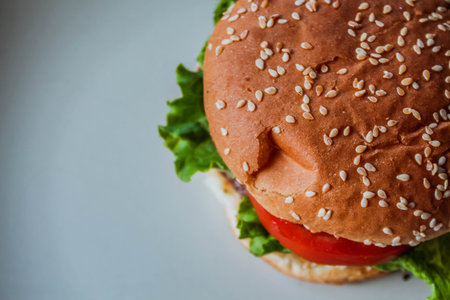 Homemade cheeseburger on white background with space, side view. Close-up burger.