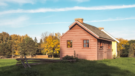 Panoramic view of farm landscape and houses in the autumn season. Trees with orange red green leaves. Green fieldの写真素材