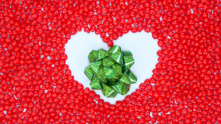 Boxing Day concept with space for text decorated with sparkling green bow in a heart against red...