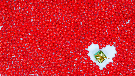 Christmas holidays concept with space for text small green gift in heart shape against red color peppermint heart shaped candies background. New Year, Birthday gift, Valentines day, Love.の写真素材