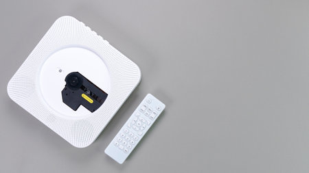Stylish white portable compact CD player with controller on grey background. Retro vintage trending disc player. Top view, copy space, space for text. Hobby entertainment leisure.の写真素材