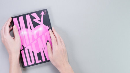 Hands holding Stray Kids MAXIDENT mini Album Box set on grey. Pink music CD. South Korean boy band StrayKids. Space for text. Gatineau, QC Canada - December 07 2022.のeditorial素材