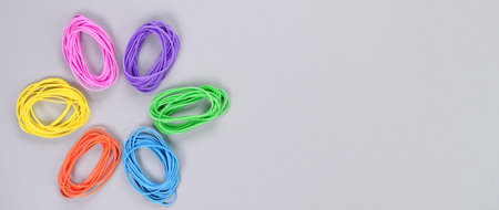 Multicolored flower made of elastic. Top view of colorful rubber bands isolated on white. Rainbow elastic rubber bands on white. Rainbow flower shapeの写真素材