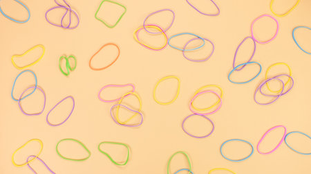 Colored rubber bands for money on bright yellow paper background. Abstract background. Stationery...
