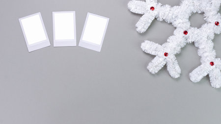 Polaroid retro photo frames isolated on grey background. Real photo template. Three frames. Mockup. Christmas white fluffy snowflake. Winter decoration..の写真素材