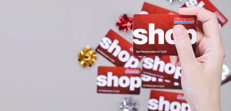 Hand holding Costco wholesale red color gift card on grey background. Shopping, gift card, shop. Gatineau QC Canada - December 21, 2022のeditorial素材