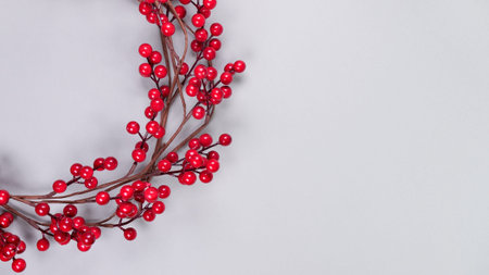 Colorful background with strips of red berry garland on grey. Festive Christmas birthday decoration garland. Space for textの写真素材