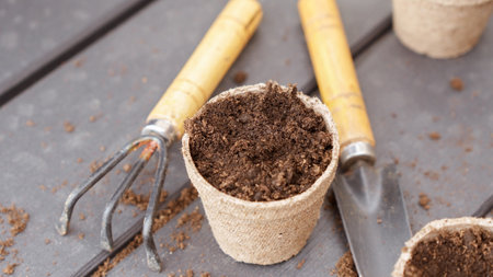 Close up of eco friendly biodegradable peat pots and garden tools, top view, selective focus. Spring natural gardening, eco, plant care, organic product.の写真素材