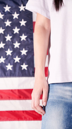 Close up of woman body and hand against american flag at 4th july. Faceless. Independence day, celebration, patriotism and holidays conceptの写真素材