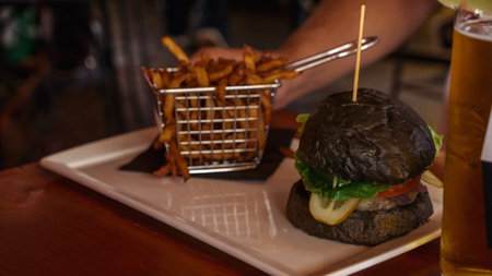 Vegan burger with French fries. Burger with plant based meat cheese. Lunch is on the table. Close-up of a hamburger with cheese on a board.Classic burger. Food dayの写真素材