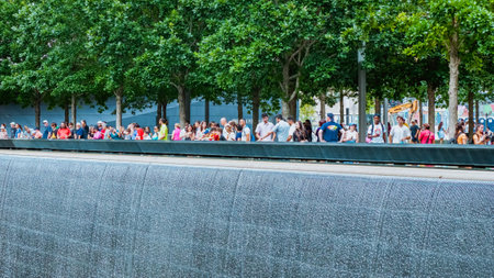 People at Ground Zero Memorial Manhattan for September 11 Terrorist Attack with Engraved Names of Victims. Patriot Day - New York NY USA 2023-07-30.のeditorial素材