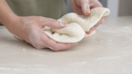 Hands Shaping the dough into ball by hand. chef Preparing the dough for baking pizza bread in the restaurant, baking.の写真素材