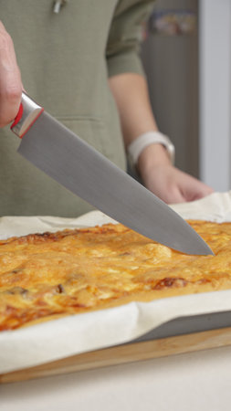Close up video of woman cutting pizza with knife. Home made pizza. Fresh baked vegetarian pizzaの写真素材