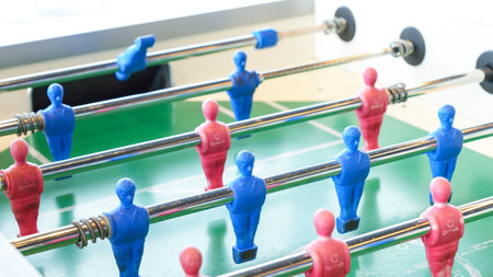 Exciting table football game featuring blue and red players competing on a vibrant green field.の写真素材
