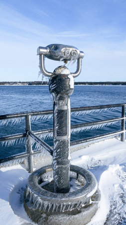 Frozen View Through a Public Telescope Sights Overlooking Icy Lake.の写真素材