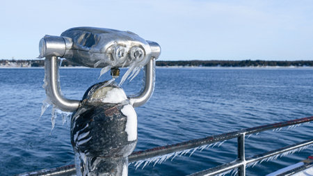Frozen View Through a Public Telescope Sights Overlooking Icy Lake.の写真素材