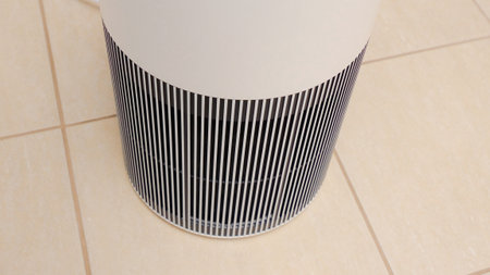 Sleek Modern Tall Air Purifier with Black Fan on Beige Tile Floor in Stylish Room.の写真素材