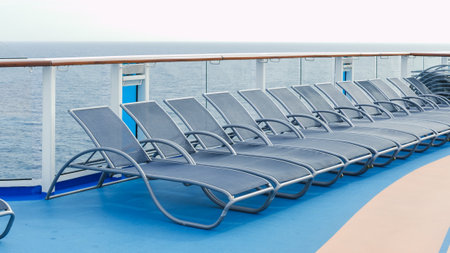 A serene view of blue deck chairs perfectly arranged in neat rows on a luxurious cruise ship deckの写真素材