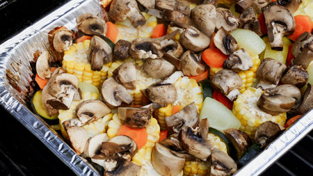 This delightful medley features grilled corn, mushrooms, carrots, zucchini, and onions, creating a nutritious and tasty side dish, perfect for summer barbecues or as a meatless main course.の写真素材