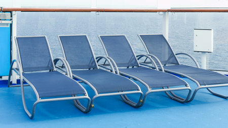 A serene view of blue deck chairs perfectly arranged in neat rows on a luxurious cruise ship deckの写真素材