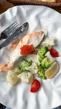 Savor this elegant salmon dish, featuring fresh vegetables and a touch of caviar. A delightful blend of flavors and presentation, perfect for a memorable dining experience.の写真素材