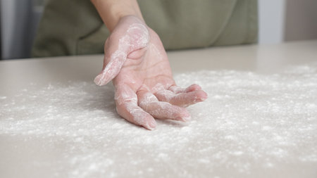 Hands, flour and baking by woman in a kitchen for bread, pizza or handmade food at home. Wheat, palm and female chef with messy fingers from cooking, fun and preparing diy, pasta or cake in her houseの写真素材