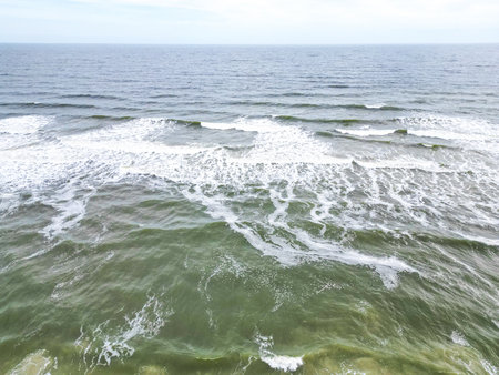 This breathtaking photo captures the vastness of the ocean from a bird s eye view. The waves display a beautiful blend of deep azure blue and foamy white, showcasing the crystal clear waters below.の写真素材