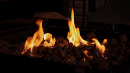 Enjoy the warm glow of a fire pit with lava rocks, ideal for outdoor gatherings. Perfect for cozy evenings, toasting marshmallows, and creating an inviting atmosphere.の写真素材