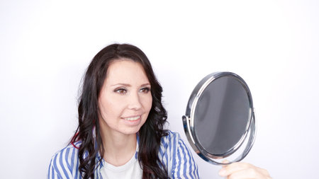 Young Woman with a problem skin looking at the mirror. Treatment for acne. Dermatology, cosmetology, skin careの写真素材