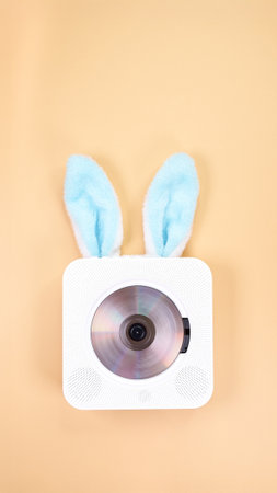 A whimsical portable CD player with fluffy blue Easter bunny ears, set against a pastel background. This playful design captures the joyful spirit of Easter, ideal for children s music themes.の写真素材