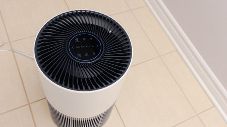 Close up view of Air Purifier with Black Fan. Black Round Electronic Device with Buttons and Bright Lights on White Background.の写真素材