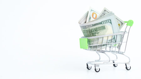 A small shopping cart overflowing with stacks of hundred dollar bills, representing wealth and...