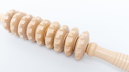Wooden cellulite treatment tool showcases an ergonomic design with rounded rollers, perfect for massage therapy and skin rejuvenation at homeの写真素材