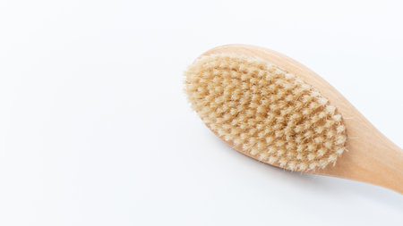 Wooden cellulite treatment brush features natural bristles, designed for effective skin care, emphasizing ergonomic shape and texture for body wellness routinesの写真素材