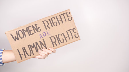 A striking image of a hand holding a sign that reads Women s Rights are Human Rights. Suitable for articles and campaigns focused on gender equality and social justice advocacy.の写真素材