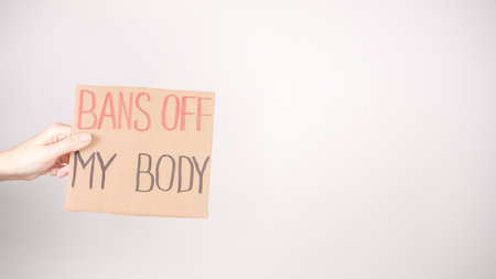 A hand holds a BANS OFF MY BODY sign, advocating for women s reproductive rights and bodily autonomy. This powerful message highlights the importance of activism and women s health.の写真素材
