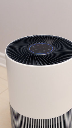 Sleek Modern Tall Air Purifier with Black Fan on Beige Tile Floor in Stylish Room.の写真素材