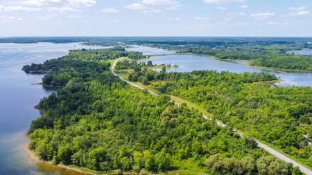 Aerial perspective reveals a vibrant green landscape with winding river and serene lakes,...